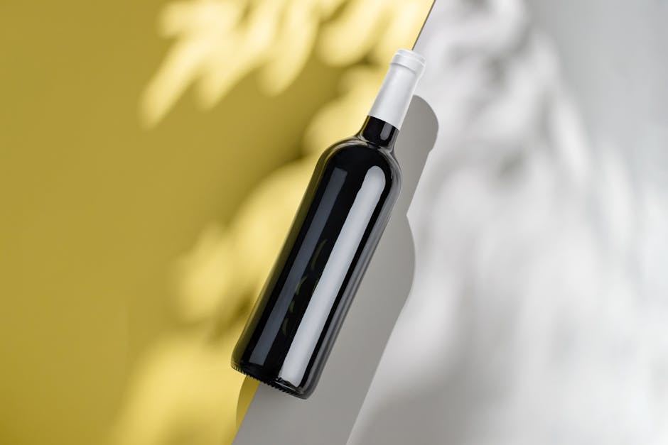 Photograph of a wine bottle with artistic shadows on a minimalist background.