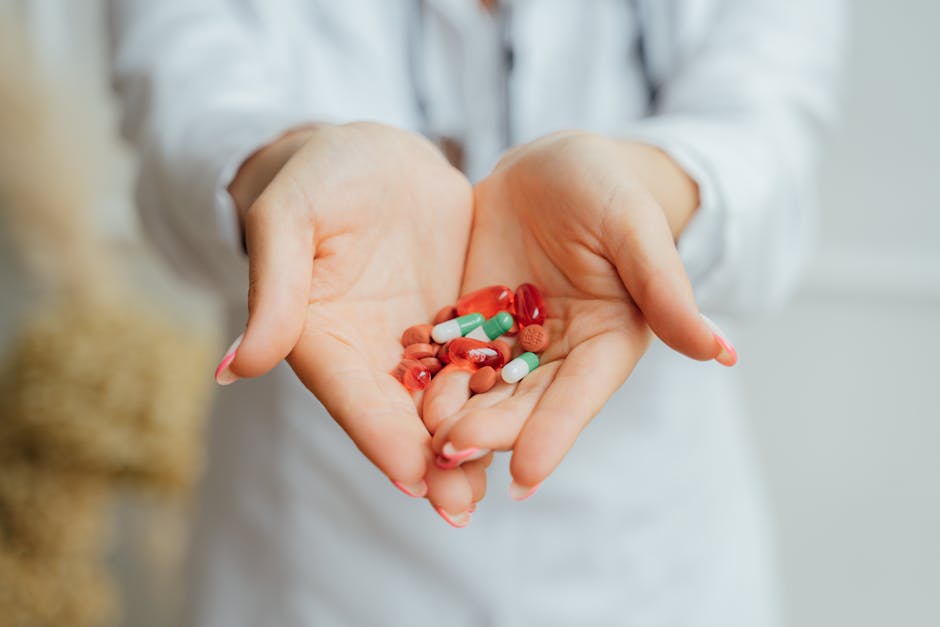 A close-up image of female hands holding diverse colorful pills and capsules.