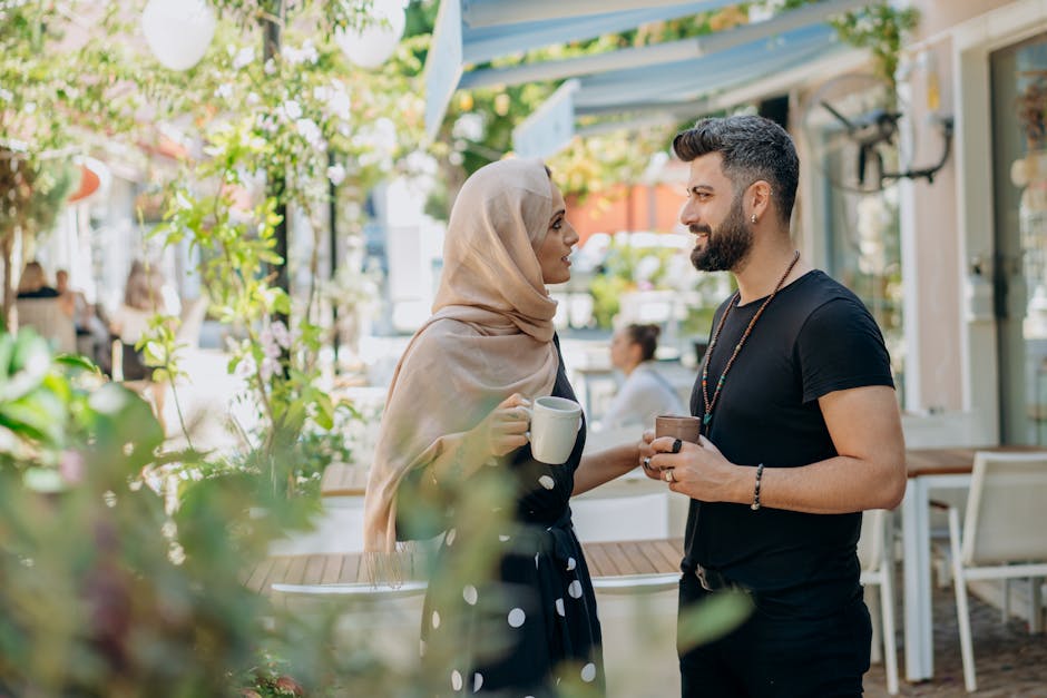 A couple enjoying coffee outside a sunlit cafe, engaging in a lively conversation and sharing a joyful moment together.