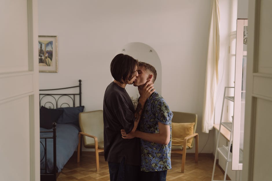 A couple embraces affectionately in a stylish bedroom setting, conveying love and intimacy.