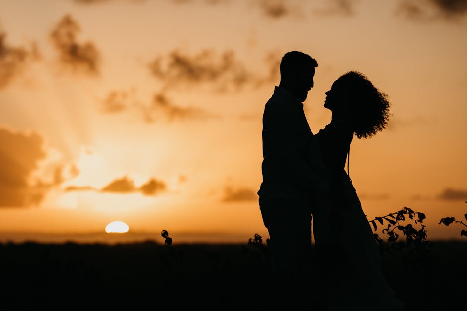 Silhouette of a couple embracing as the sun sets, capturing a romantic and serene moment.