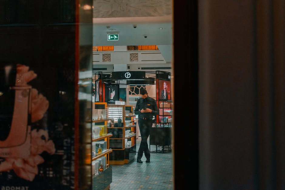 Man in a retail store in Saint Petersburg using a phone. Interior view through glass.