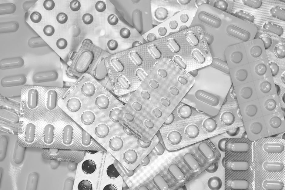 Monochrome close-up of assorted blister packs with pills, highlighting pharmaceutical packaging.