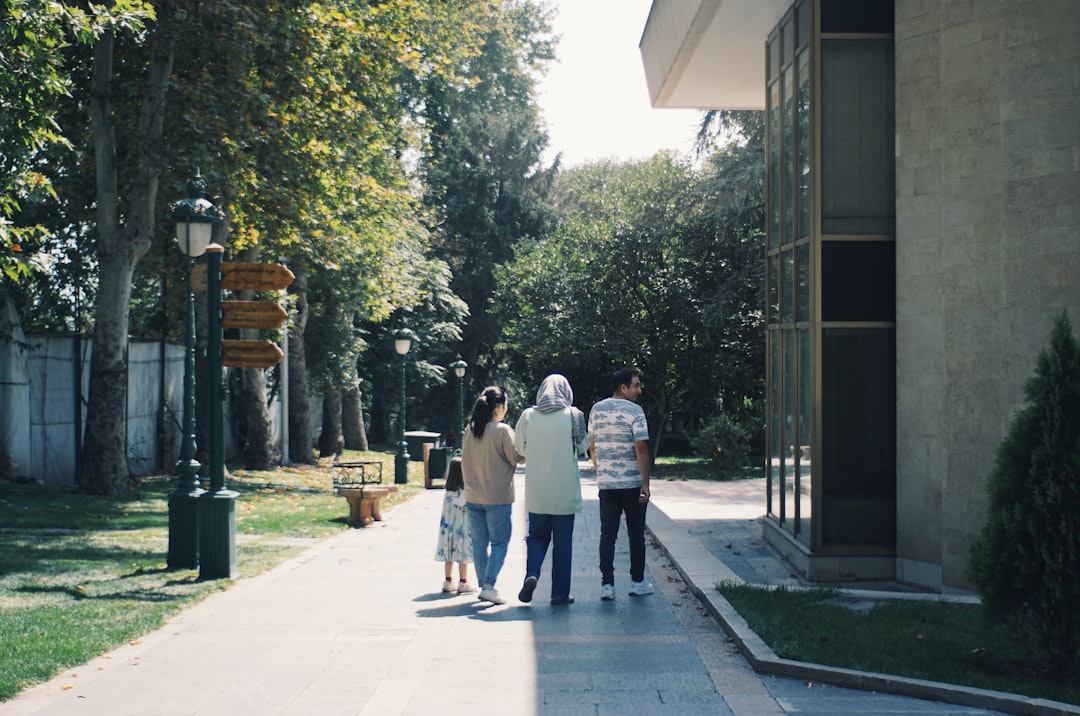 People walking on a path next to a building.