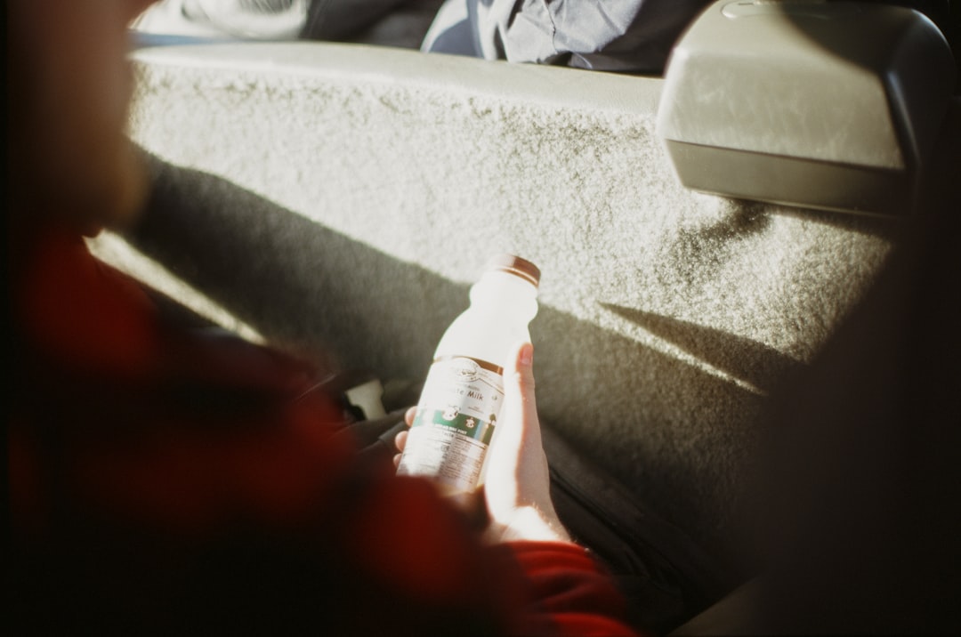 Person holding a bottle in a car