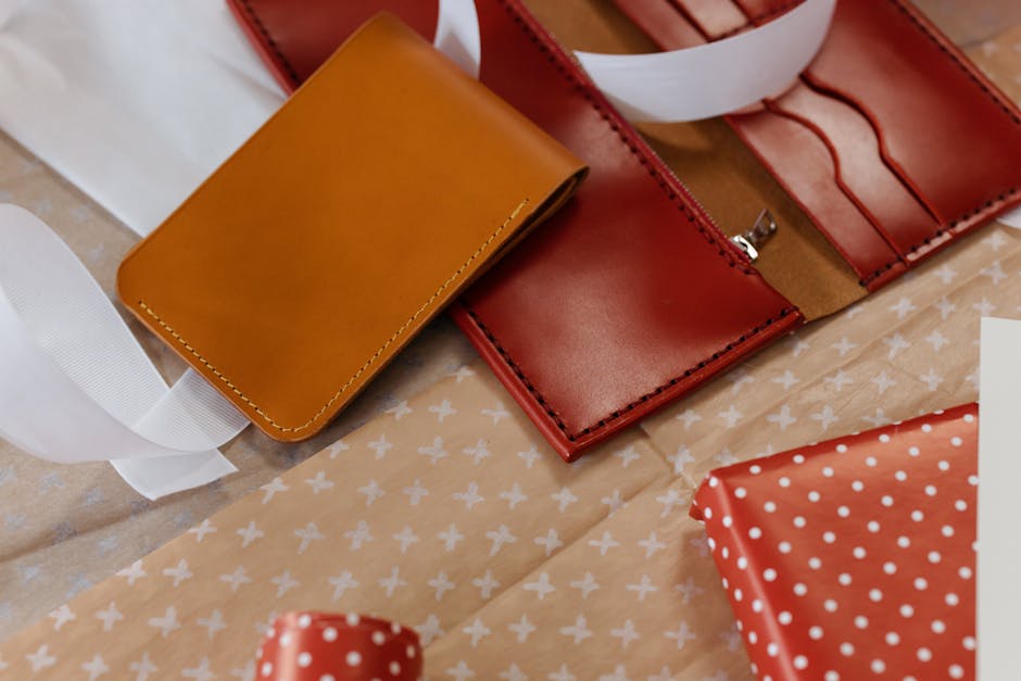 Elegant leather wallets with ribbon and gift wrapping paper.